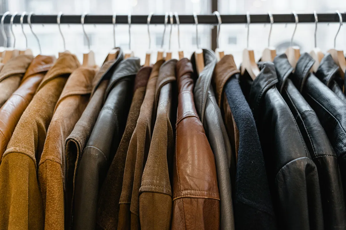 Rangée de vestes et blousons en cuir marron, camel et noir sur un portant